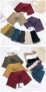 Détail de châles en maille crochet colorée avec bordure en perles et nœud papillon