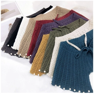 Détail de châles en maille ajourée avec bordures en perles disponibles en plusieurs coloris