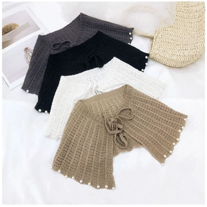 Détail de châles en tricot avec bordure en perles en gris foncé, noir, blanc et kaki