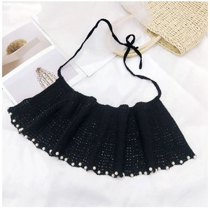 Détail d'un col au crochet noir avec perles blanches et cordons de serrage élégants