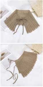Détail d'un châle au crochet orné de perles blanches et d'une bordure évidée festonnée