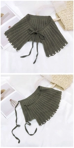 Détail de châle en maille vert olive avec perles blanches et cordon de serrage réglable