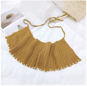 Détail d'un châle en tricot jaune avec volants au crochet et bordures en perles blanches