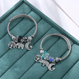 Silver stainless steel wire bracelet with elephant, moon, and tree of life charms