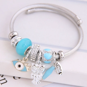 Adjustable stainless steel bangle with owl and blue evil eye charms in silver tone