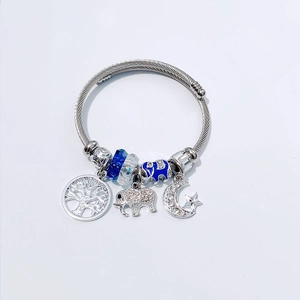 Detail of steel wire bangle with blue beads and tree of life, elephant, moon charms
