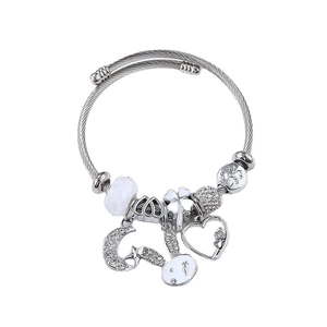 Silbernes Kabelarmband mit Mond-, Stern-, Herz- und Kleeblatt-Anhängern auf weißem Grund