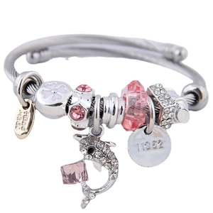 Silver woven bracelet with pink dolphin pendant and crystal beads on white background