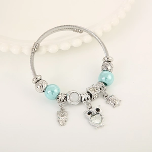 Stainless steel owl and sea turtle charm bracelet with blue beads on white porcelain