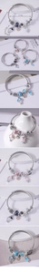 Macro shot of silver twisted metal bracelet featuring rabbit, crown and balloon charms