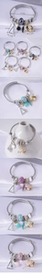 Detail of beaded stainless steel bracelets with shell charms and crystal beads
