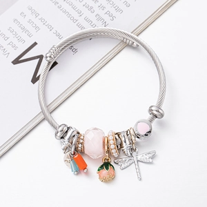 Beaded cable bracelet featuring dragonfly, pearl, and pink floral pendants on silver band
