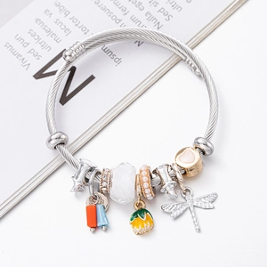 Beaded charm bracelet with dragonfly, heart, and floral pendants on a silver twisted wire band