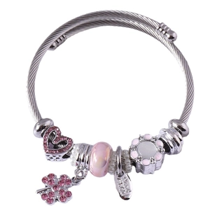 Silver bead bracelet with pink crystal heart and clover charms on a white background