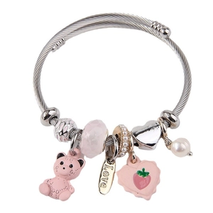 Silver woven steel wire bracelet with pink GG bear and crystal heart charms on white background