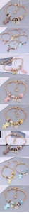Detail of gold-tone charm bracelet featuring resin bears and sparkling heart charms