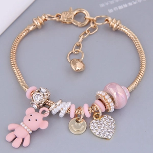 Golden heart bracelet with pink bear charm and zircon beads on a snake chain