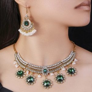 Vintage bohemian jewelry set with green emerald gems and pearl tassels on model