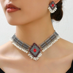 Vintage silver jewelry set with red stones and pearls worn by a model