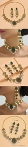 Détail d'un ensemble de bijoux dorés vintage avec pierres émeraude et perles