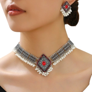 Parure de bijoux bohème vintage avec gemmes rouges et perles blanches sur collier et boucles