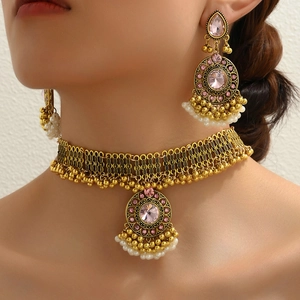 Vintage bohemian jewelry set with pink gemstones and white pearls on gold metal