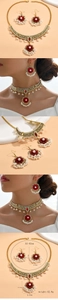 Detail of vintage gold flower necklace and pearl earrings with red stone accents