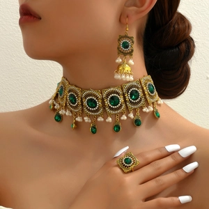 Vintage gold jewelry set with green gemstones and pearls including necklace and earrings