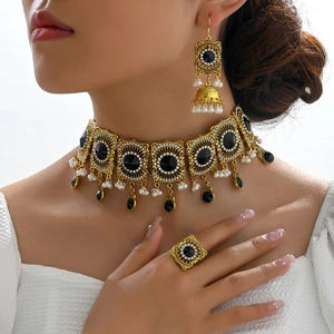 Vintage gold-tone jewelry set with black gemstones and pearls on a model