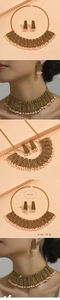 Detailed view of vintage gold necklace and earring set with pearls and brown beads
