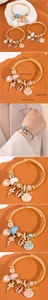 Details des goldenen Boho-Armreifs mit Perle, Muschel und Märchen-Anhängern