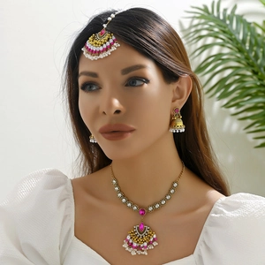 Vintage Indian style jewelry set with pink stones and beads on model, gold finish