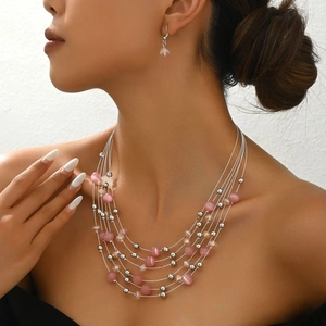 Bohemian multi-layer necklace set with pink cat-eye stones and crystal beads on a model