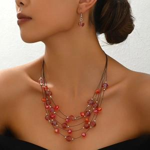 Bohemian multi-layer red beaded necklace and earring set shown on a female model