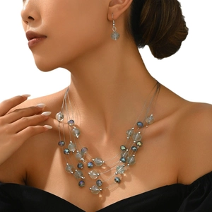 Detail of multi-layer beaded necklace and earrings set with grey faceted crystals