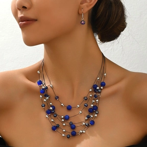Detail view of multi-layered beaded necklace with blue cat eye stones and earrings