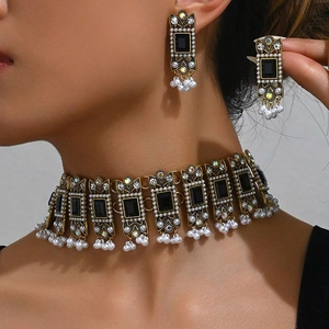 Indian style jewelry set with black gemstones and pearls on gold choker and earrings