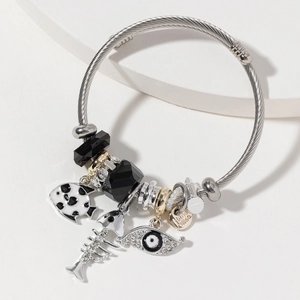 Stainless steel cable bracelet with evil eye and fish charms in 45-degree view