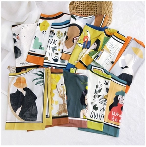 Artistic silk scarves with cartoon patterns and abstract prints laid on white cloth