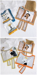 Artistic silk scarves with cartoon and letter prints displayed on a textured background