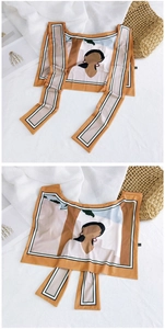 Detailed view of yellow cartoon silk scarf with minimalist art on pleated fabric