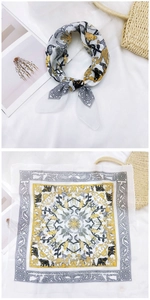Detail of printed silk scarf featuring yellow giraffes, elephants and vintage patterns