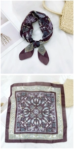 Detail of square silk scarf with elephant and floral prints on wine red fabric