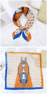 Detailed view of horse-print silk scarf with equestrian motif in orange and blue