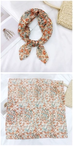 Close-up of cotton linen square scarf with orange floral pattern and tied styling detail