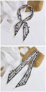 Gros plan du foulard en soie à motif géométrique noir et blanc sur fond décontracté