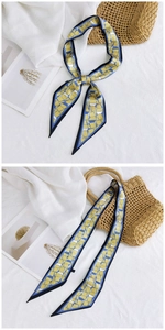 Détail d'un foulard en soie à motif géométrique jaune et bleu avec bordures noires