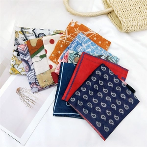 Various patterned cotton linen scarves in paisley and polka dot prints on a white fabric