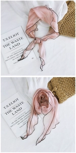 Detailed close-up of pink mesh scarf with black lettuce edge and elegant floral styling