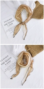 Close-up of champagne sheer mesh scarf with black wavy edges on aesthetic background